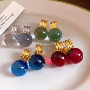Eleganti orecchini vintage con pendenti tondi in resina in oro e argento su un piatto