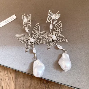 Detailansicht der hohlen Schmetterlingsohrringe mit Zirkonia und Barockperlen
