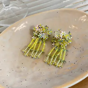 Macro view of elegant floral tassel earrings with yellow glass beads and sequins