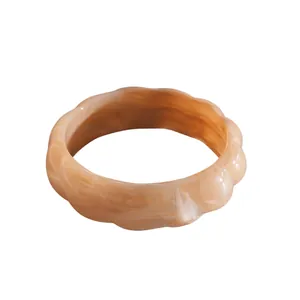 Elegante bracciale rigido in acrilico marmorizzato con bordi smerlati