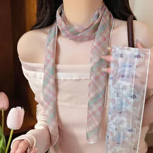 Detail eines eleganten karierten Netzschals, getragen von einem Modell im Licht.