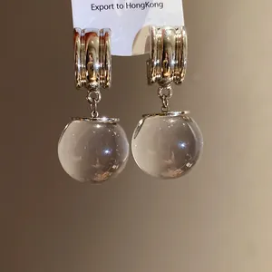 Primo piano di orecchini vintage in argento con sfere di resina e cerchi in metallo