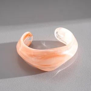Dettaglio di un bracciale rigido in acrilico marmorizzato con motivo a spirale pesca