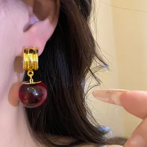 Dettaglio di orecchini vintage in resina a sfera con perno dorato dal design a costine