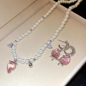Close-up view of a sweet pink strawberry pearl necklace and earring jewelry set.