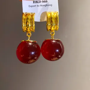 Orecchini stile vintage con grandi sfere in resina rossa e finitura metallica oro
