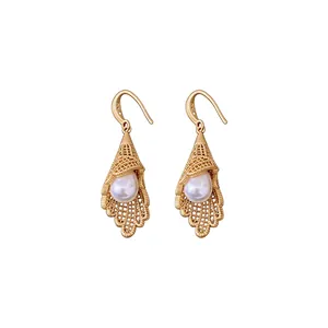 Elegant gold hollow lace earrings with pearl drop pendants on white background