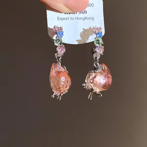 Detailed macro shot of sweet pink strawberry drop earrings with colorful gemstones