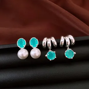 Dettaglio di orecchini in argento stile francese con pietre di zircone verde e perle