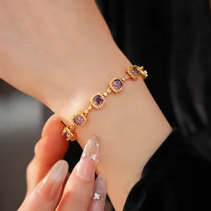 Elegant vintage gold-plated bracelet featuring purple zirconia and round crystal charms on wrist