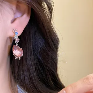 Close-up of sweet pink strawberry drop earrings with multi-colored beads worn on ear