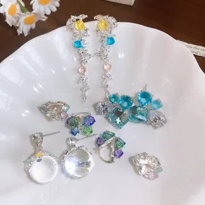 Gros plan de plusieurs boucles d'oreilles géométriques en zircon sur une assiette