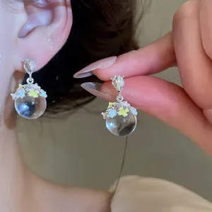 Gros plan de boucles d'oreilles élégantes en cristal avec zircon et fleurs colorées