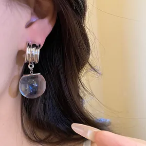 Dettaglio di un orecchino vintage in argento con pendente sferico in resina trasparente