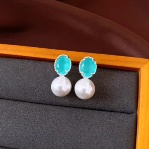 Primo piano di eleganti orecchini in argento con zircone turchese e perle bianche.