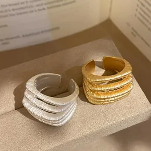 Close-up detail showing the multi-layer textured finish of 18k gold and silver plated rings