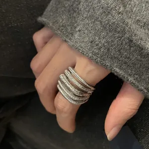 Detailed view of textured silver multi-layer open ring worn on index finger