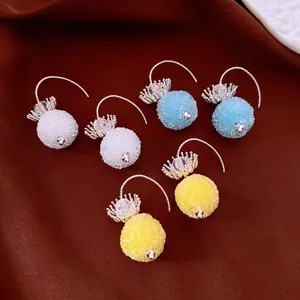 Close-up of crystal flower round ear hook earrings in white, blue and yellow
