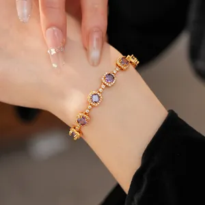 Close-up of a vintage gold-plated bracelet with purple amethyst stones worn on a model's wrist