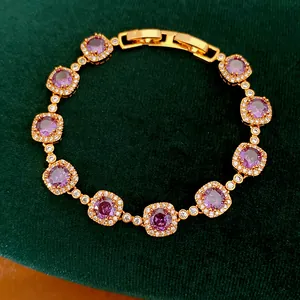Close-up of a vintage gold-plated bracelet with purple CZ stones and clasp detail.