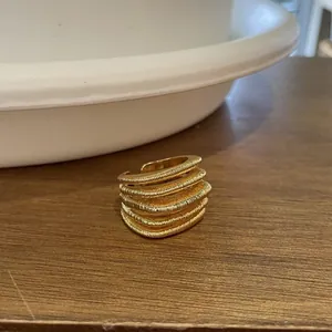Detailed view of an 18k gold plated multi-layer textured open ring with square design
