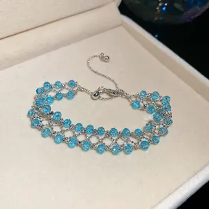Detailed view of elegant ice-blue zircon hollow woven bracelet in a beige jewelry box