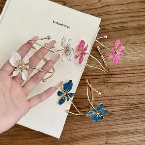 Elegante goldene Oberarmreifen mit Emaille-Blumen in Weiß, Rosa und Blau