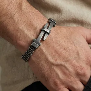Detail of men's stainless steel mesh woven chain bracelet with vintage belt buckle design