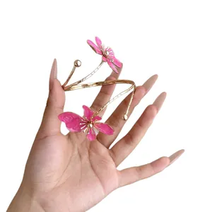 Eleganter goldener Armreif mit filigranen rosa Emaille-Blumenakzenten für stilvolle Damen