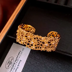 Close-up of golden lace hollow cuff bracelet with sparkling zircon stones in a box