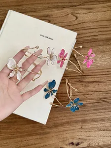 Nahaufnahme eleganter Armreifen mit Emaille-Blumen in Weiß, Rosa und Blau für Damen