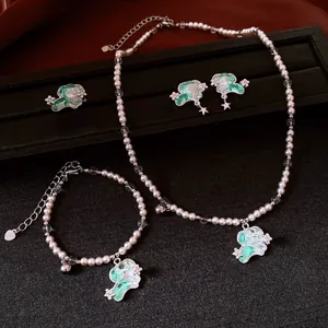 Charmant ensemble de bijoux en perles avec chiots en émail vert sur fond sombre