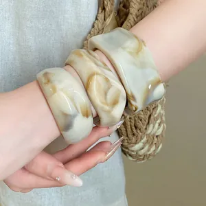 Close-up of irregular marble geometric bangles on wrist with stylish resin finish