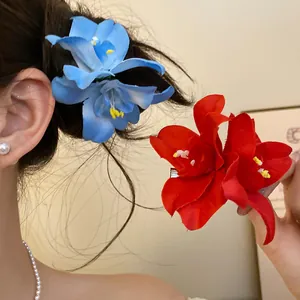 Detailed shot of vibrant red and blue fabric flower hair clips worn in hair for a stylish look