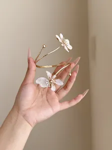 Detailansicht der weißen Emaille-Blume an der eleganten goldenen Oberarmspange