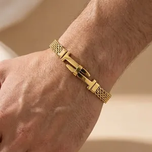 Close-up detail of gold-toned stainless steel mesh chain bracelet with iconic H-shaped buckle design