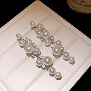Detailed macro view of elegant silver drop earrings with white pearls and sparkling crystals