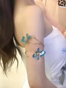 Detailansicht eines eleganten blauen Emaille-Blumen-Armreifs am Oberarm eines Models