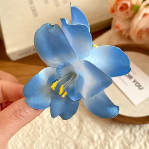 Close-up of a blue fabric flower hair clip with realistic yellow stamens for a sweet look.