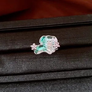 Détail macro d'une bague chiot vert mignon avec des accents floraux argentés étincelants
