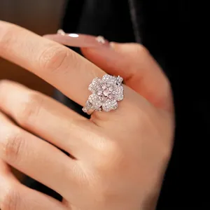 Elegant flower-shaped zircon ring with pink and white stones worn on finger
