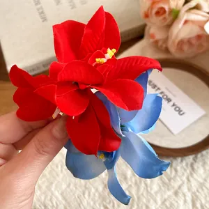 Detailed macro view of vibrant red and blue fabric flower duckbill hair clip accessory