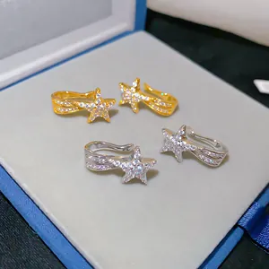 Nahaufnahme der funkelnden Meteor-Stern-Ohrclips in Gold und Silber