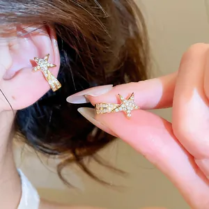 Detailansicht eines funkelnden goldfarbenen Stern-Ohrclips mit Zirkonia-Besatz
