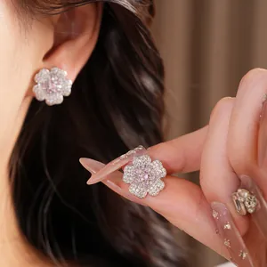Exquisite flower stud earrings featuring pink and white cubic zirconia crystals on model