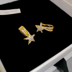 Nahaufnahme von funkelnden goldenen Sternschnuppen-Ohrclips mit brillanten Zirkonia-Steinen