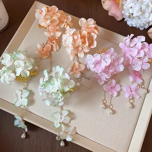 Vista macro dettagliata di petali di fiori in tessuto e nappe di perle su forcine