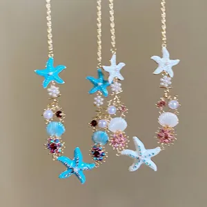 Macro view of starfish and pearl necklace detail with blue and white enamel accents.