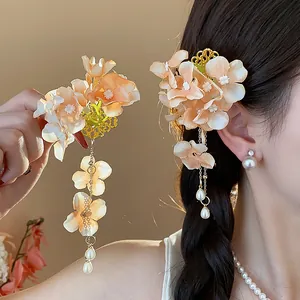 Vista laterale dell'elegante fermaglio per capelli a fiori di stoffa con nappe di perle
