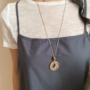 Detailansicht des unregelmäßigen Harzanhängers mit Goldfinish und braunen Perlen